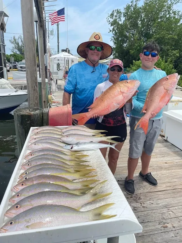 Dockside smiles and a table full of fish—nothing beats a successful day on the water.